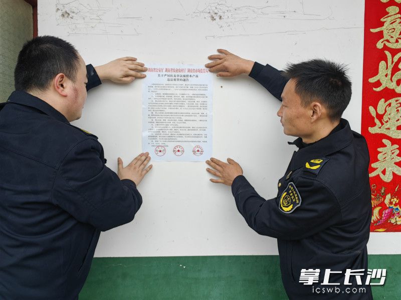 执法人员正在张贴普法宣传单。