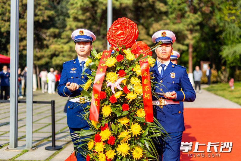礼兵抬起花篮，正步走向烈士纪念塔。