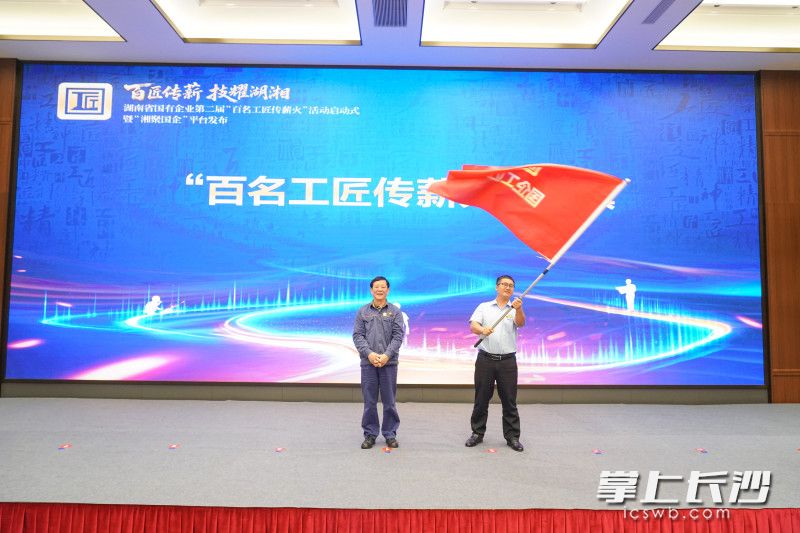 “七一勋章”获得者、大国工匠艾爱国向国企工匠代表授旗。 均为长沙晚报全媒体记者刘攀摄
