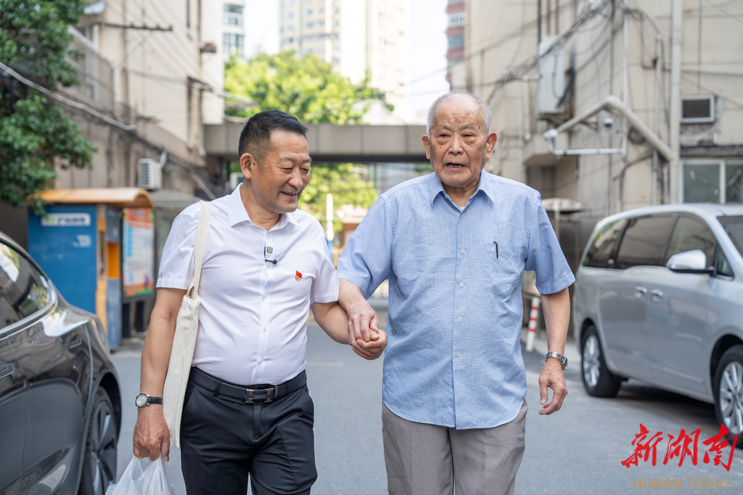 5月30日，吴建宏(左)在上海拜访沈宗桃，寻找照片背后的故事。湖南日报全媒体记者辜鹏博 摄