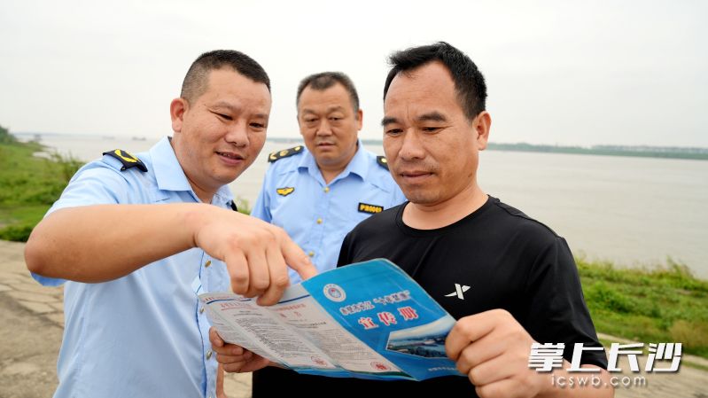 护渔员李刚（左一）和同事向市民宣传长江禁渔政策。均为咸宁日报记者毛亚轩摄